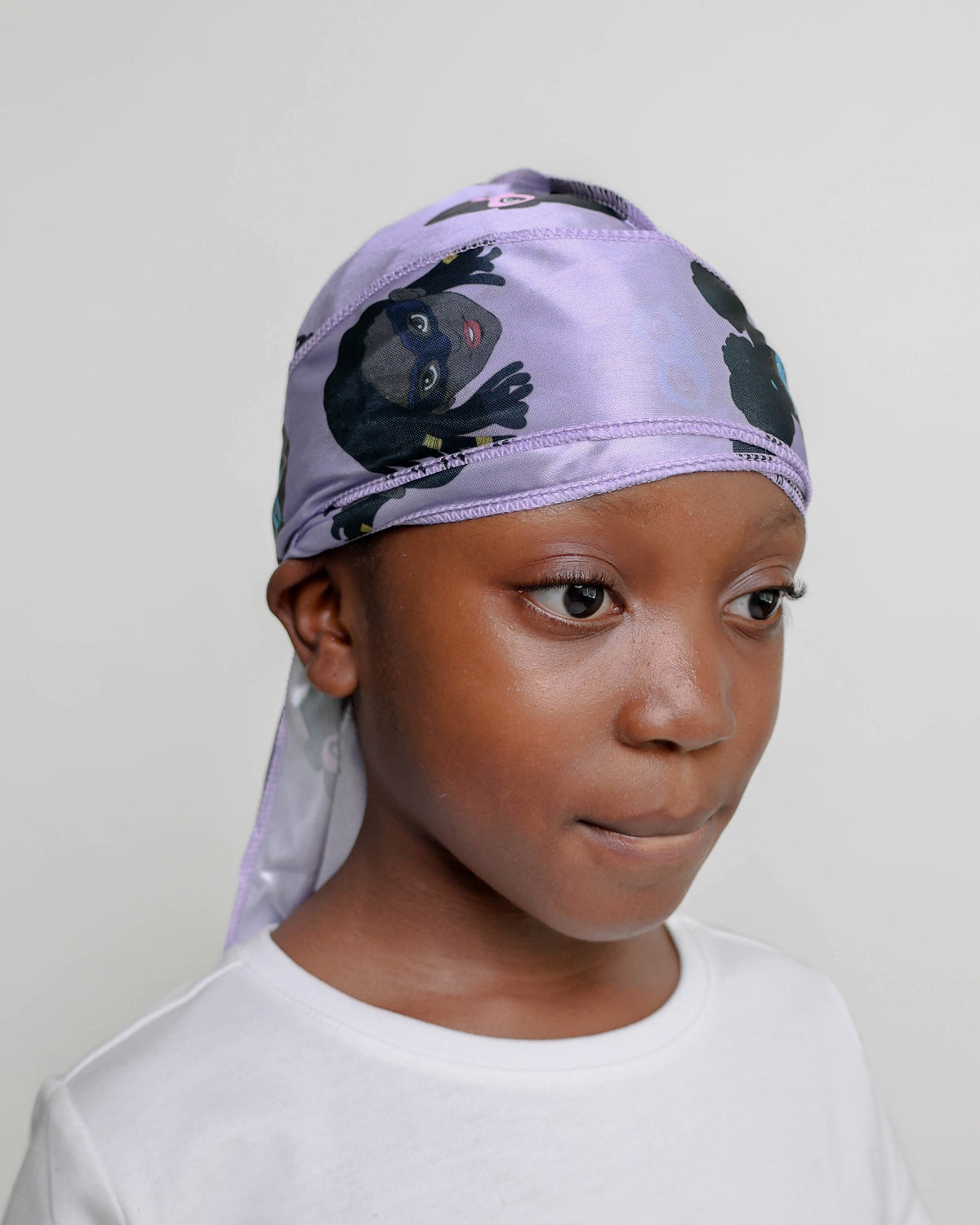 Three-quarter view of a girl wearing the lavender MY HERO kids satin durag